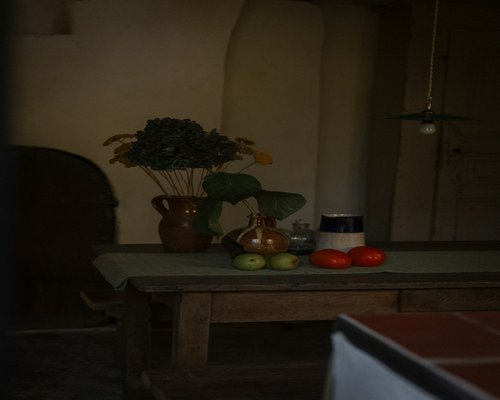 A clean domestic table setup with fresh Romanian vegetables and a water pitcher